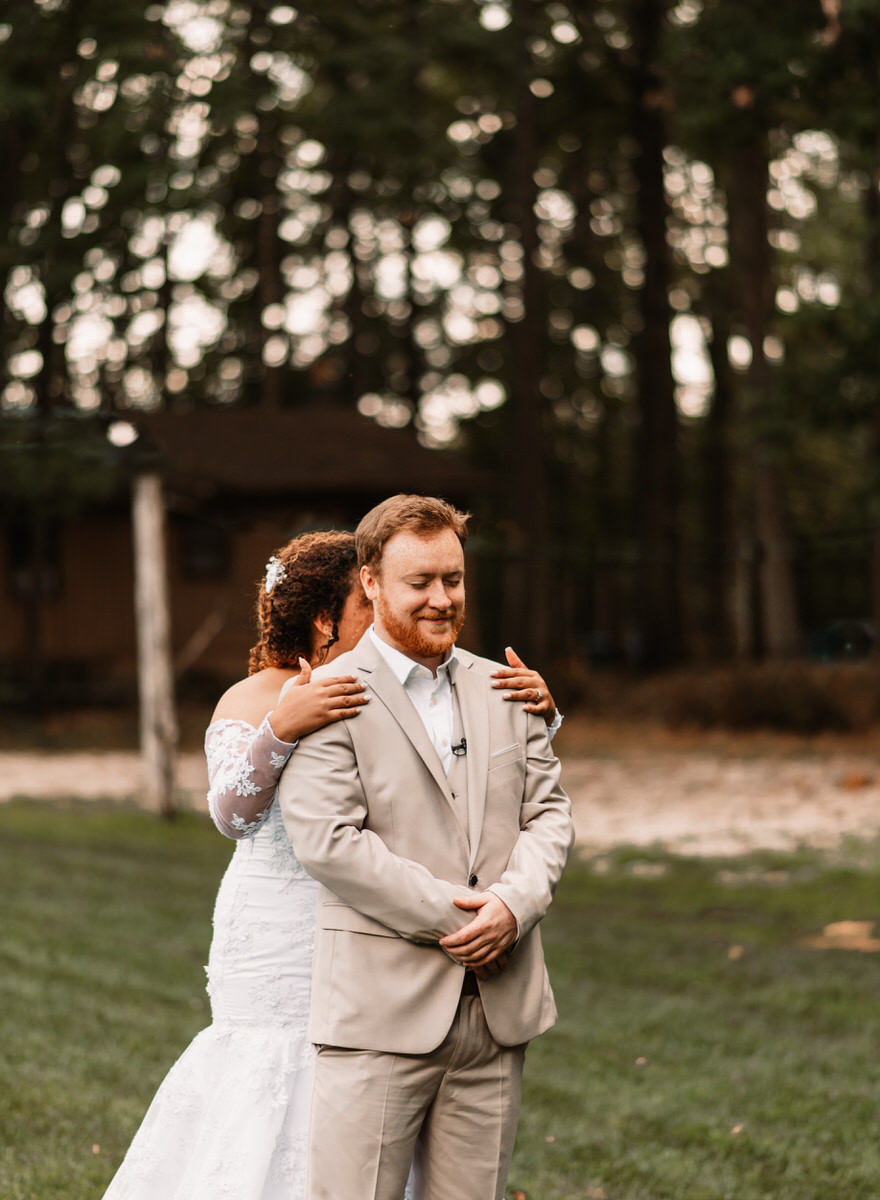 camp hidden valley venue deer creek preserve first look wedding maryland photographer bride hugging groom from behind