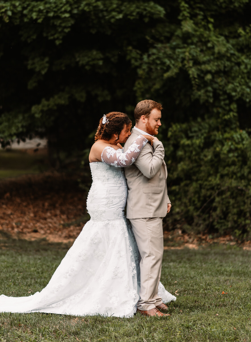 camp hidden valley deer creek preserve first look maryland wedding photographer bride hugging groom from behind 