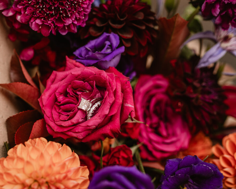 square cut diamond wedding ring inside magenta and purple roses