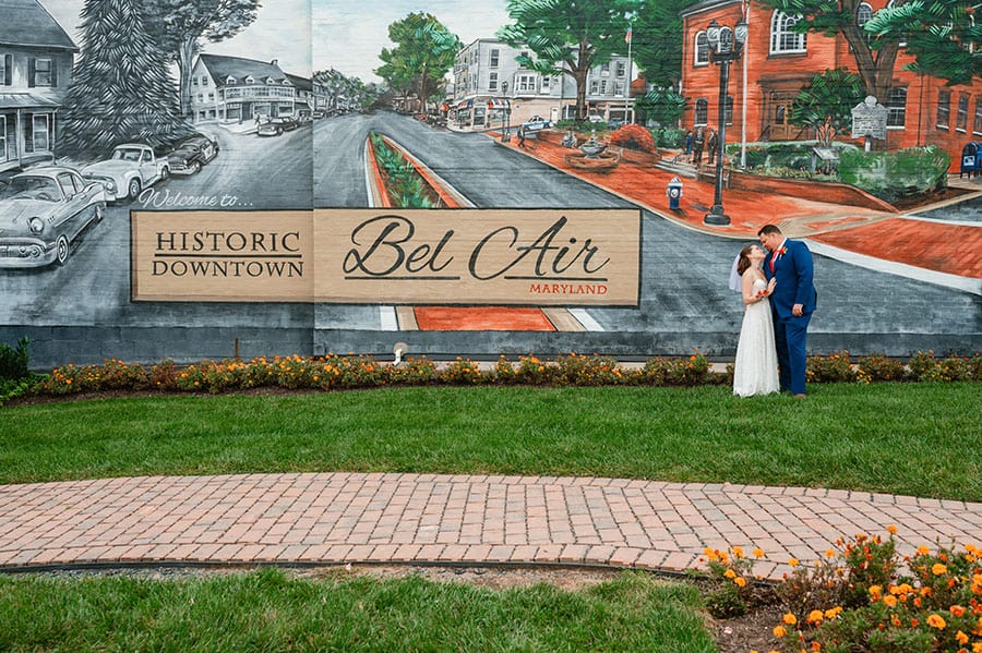 bride and groom standing in front of a full wall mural