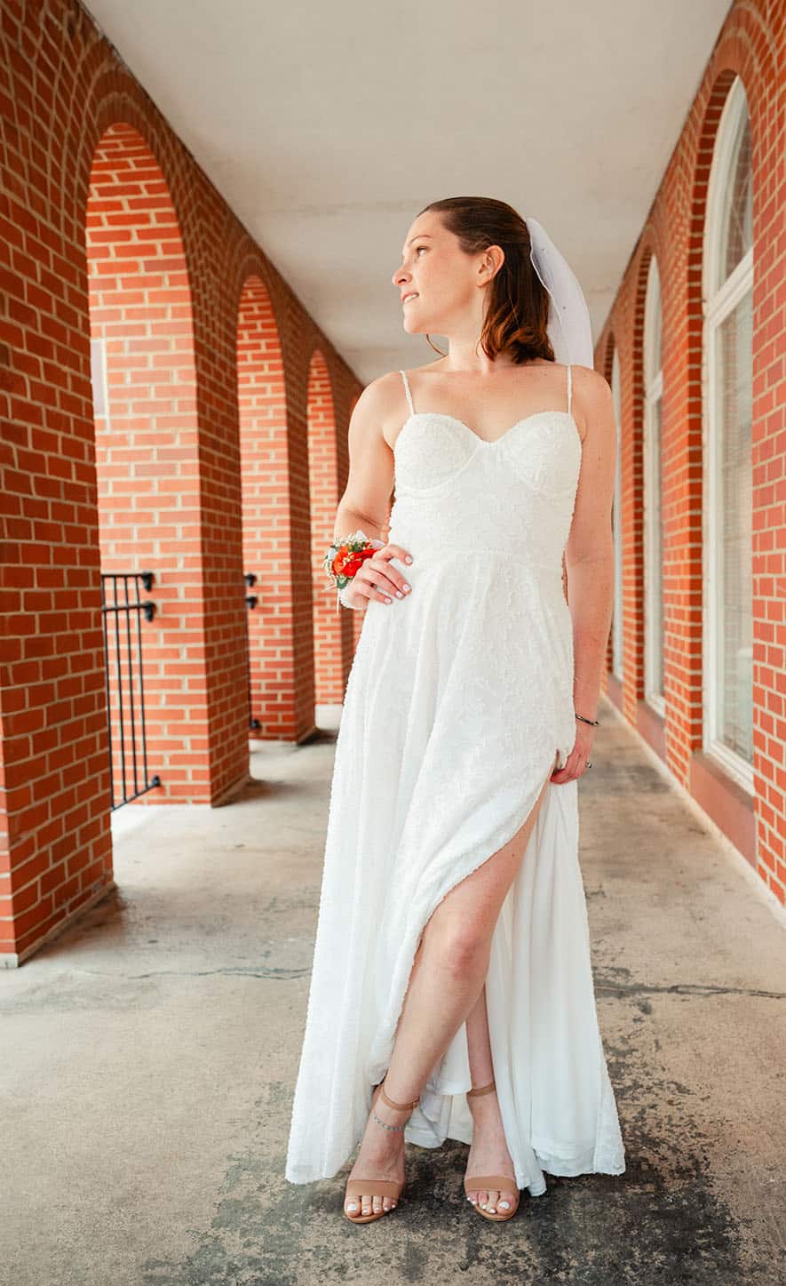 bride standing outside near brick wall