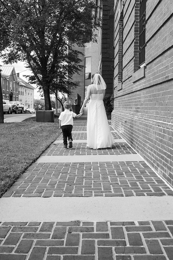 bride and little boy holding hands walking