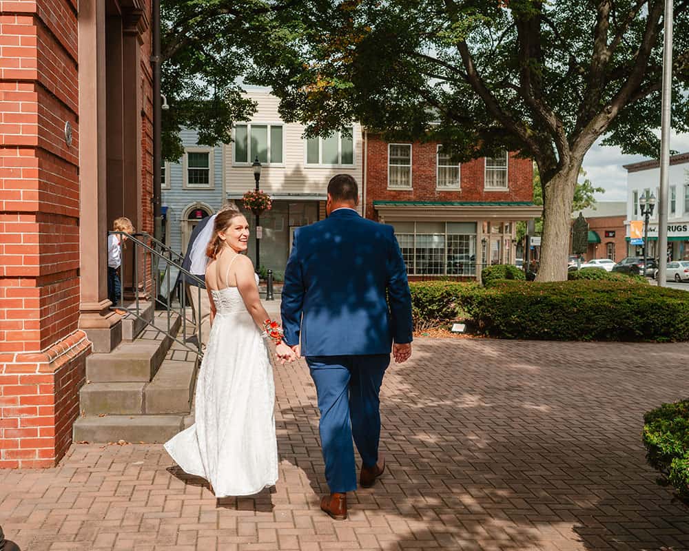 bride looking back as she and groom walk