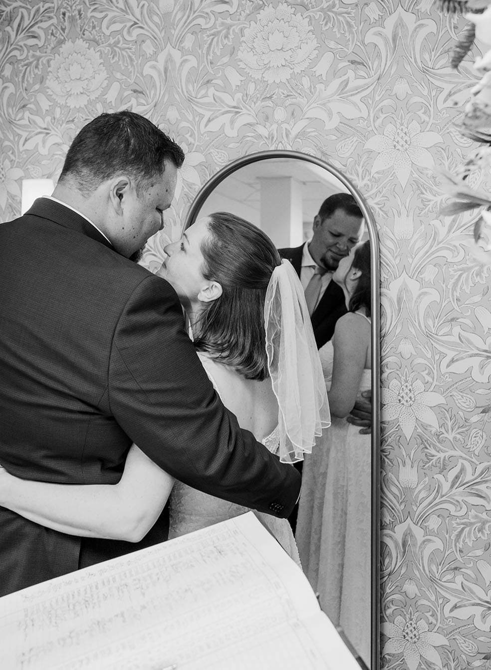 bride and groom standing in front of mirror