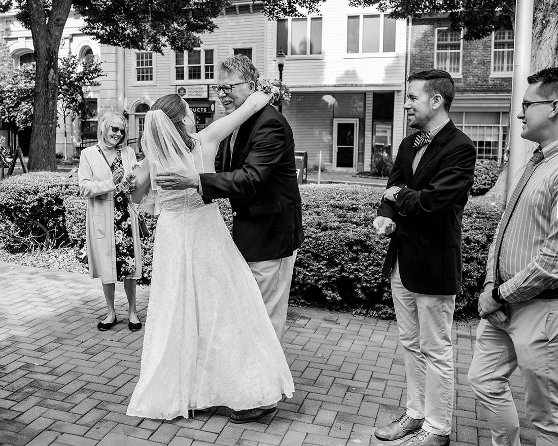 black and white image of people hugging after wedding